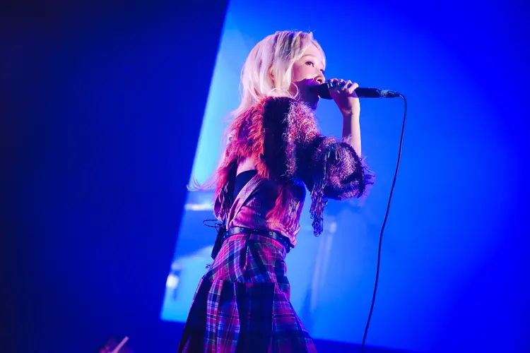A singer performing under blue stage light