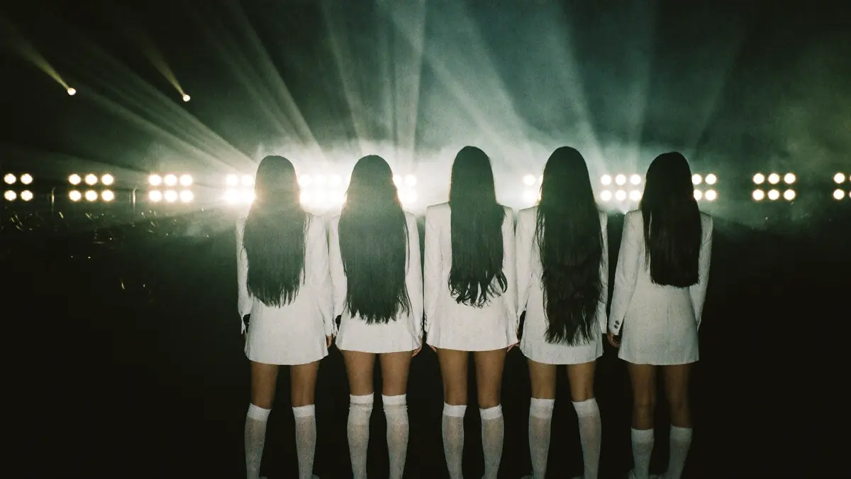 Five performers backlit by stage lights